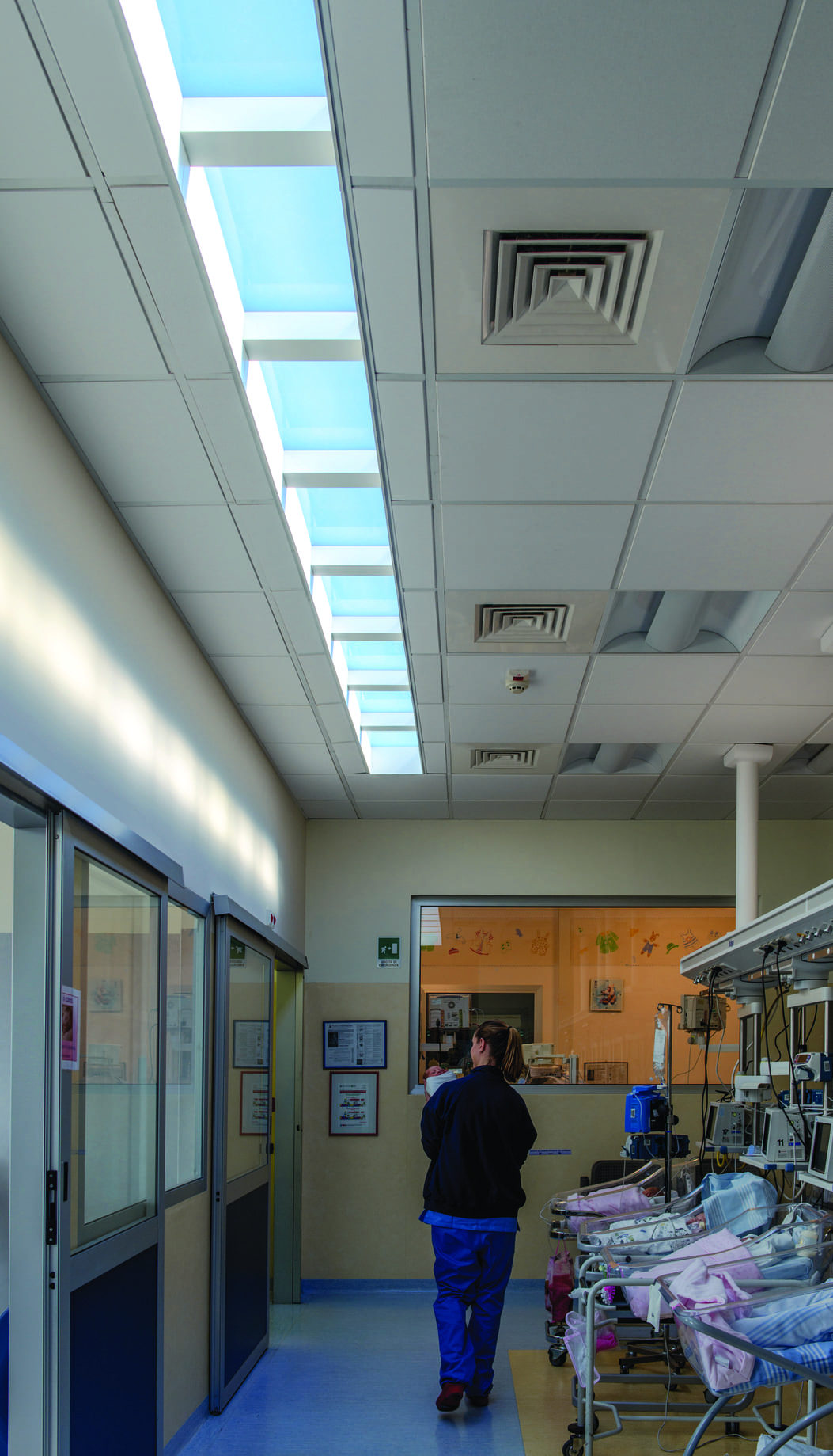 ガラス越しに見守る家族に安心感を与える青空照明空間デザイン